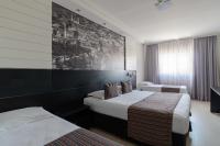 a hotel room with two beds and a painting on the wall at Faro Hotel Taubaté in Taubaté