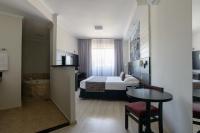 a hotel room with a bed and a table at Faro Hotel Taubaté in Taubaté