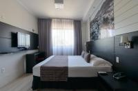 a hotel room with a bed and a television at Faro Hotel Taubaté in Taubaté