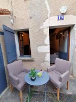 two chairs and a table in front of a building at LE BLANC, AGREABLE MAISON DE CENTRE VILLE in Le Blanc