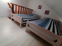 two twin beds in a room with wooden floors at LE BLANC, AGREABLE MAISON DE CENTRE VILLE in Le Blanc