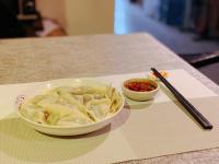 a bowl of food on a table with chopsticks and sauce at Zhangjiajie One Art Guesthouse--Attraction Tickets Service in advance,Free Calligraphy&Tea Experience,English reception service in Zhangjiajie