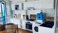 a kitchen with a washing machine and a microwave at Duplex à 50m de la plage du Diamant avec parking in Le Diamant