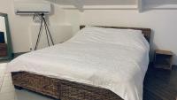 a bedroom with a bed with a white comforter at Duplex à 50m de la plage du Diamant avec parking in Le Diamant