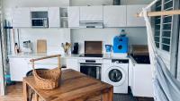 a kitchen with a washing machine and a wooden table at Duplex à 50m de la plage du Diamant avec parking in Le Diamant