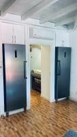 two black refrigerators in a room with a kitchen at Duplex à 50m de la plage du Diamant avec parking in Le Diamant