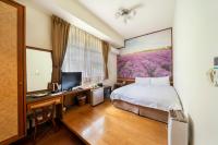 a bedroom with a bed and a desk with a tv at Tai-Yi Red Maple Resort in Puli