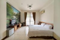 a bedroom with a bed and a flat screen tv at Tai-Yi Red Maple Resort in Puli
