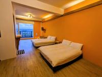 a hotel room with two beds and a balcony at Blackport Seaview Homestay in Yanliau