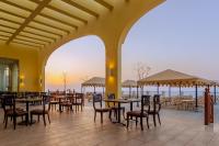 a restaurant with tables and chairs and a view of the ocean at Siva Golden Bay Makadi in Hurghada