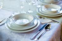 una tavola con piatti bianchi e argenteria di Complex Vața Băi a Vaţa de Jos