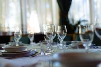 un tavolo con bicchieri da vino e piatti sopra di Complex Vața Băi a Vaţa de Jos