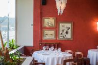 un restaurante con mesas y sillas blancas y una pared roja en Hotel Robert, en La Pobla de Claramunt
