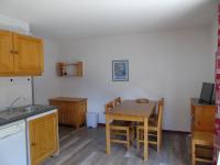 eine Küche mit einem Holztisch sowie einem Tisch und Stühlen in der Unterkunft Appartement Valfréjus, 2 pièces, 6 personnes - FR-1-561-18 in Valfréjus