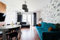a living room with a blue couch and a table at Big Apart - Atal Towers - 3 Rooms - Private Parking Place in Wrocław