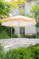 ヌイイ・シュル・セーヌにあるLe 5 Particulierのオレンジと白の傘、椅子、テーブル