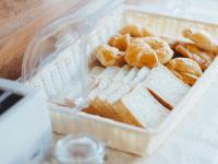 a basket of bread and pastries on a table at Rendezvous Classic House in Chiang Mai