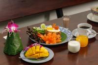 a table with a plate of food and a cup of coffee at Rendezvous Classic House in Chiang Mai