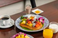 a plate of food with fruit and a cup of coffee at Rendezvous Classic House in Chiang Mai