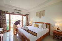 a man standing next to a bed in a bedroom at Rendezvous Classic House in Chiang Mai