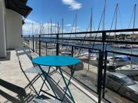 un balcon avec une table et des chaises et un port de plaisance dans l&#39;établissement Maison entre port et plage, à Mèze