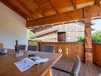 a wooden table and chairs on a wooden deck at Obinghof in Söll