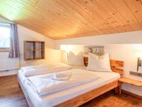two beds in a room with a wooden ceiling at Obinghof in Söll