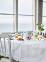 stół z białym ściereczkiem i zestawem do parzenia herbaty w obiekcie Grand Hôtel Mölle w mieście Mölle