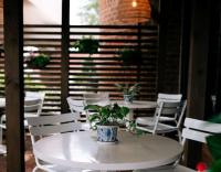 a table and chairs with a potted plant on it at Hilton Greenville in Greenville