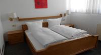 a bed with white sheets and pillows on it at Hotel Specht in Witten