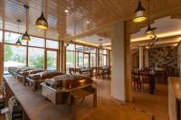 uma fila de mesas num restaurante com janelas em Sand Dunes Retreat em Leh