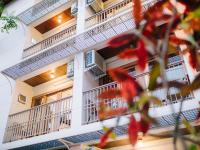 a building with balconies and red flowers in the foreground at Rendezvous Classic House in Chiang Mai