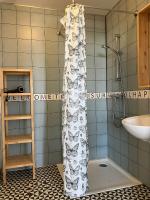 a shower curtain with butterflies on it in a bathroom at Maison avec Jardin près des Plages in Le Bernard