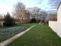 a yard with a fence and a field of grass at Maison avec Jardin près des Plages in Le Bernard