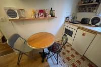 a small kitchen with a table and two chairs at Lovely love nest near Paris in Clichy