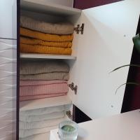 a closet with colorful towels on shelves at Maison calme&#47;Chambre privée&#47;Clim+TV&#47;Pétit dejeuner inclu&#47;tout confort in Nevers