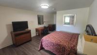 Un dormitorio con una cama y un televisor de pantalla plana. en Mount Airy Motel, en Mount Airy
