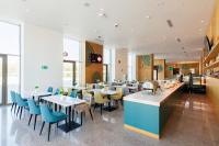 a restaurant with white tables and blue chairs at M-clinic Hotel in Tashkent