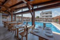 a restaurant with a swimming pool with tables and chairs at Aparthotel Plat in Kožino