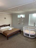 a bedroom with a bed with a crib in it at Guest house Shulc in Mizhhirya