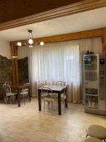 a dining room with a table and chairs and a refrigerator at Guest house Shulc in Mizhhirya