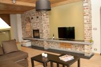 a living room with a tv and a brick fireplace at B&amp;B - Ter Douve in Dranouter
