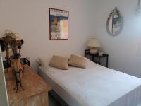 a bedroom with a bed and a table and a poster at 4SAP22 Appartement climatisé avec double terrasses in Collioure