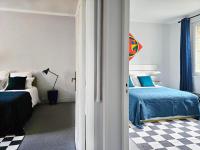 a bedroom with two beds and a checkered floor at L&#39;Idrac, Appartements en Hyper centre in Toulouse