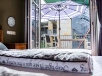 a bed with an umbrella in front of a balcony at Minjo Hotel in Bad Kreuznach