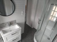 a white bathroom with a sink and a shower at La Parenthèse Clissonnaise plein centre historique in Clisson