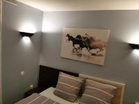 - une chambre avec un lit avec 2 chevaux sur le mur dans l&#39;établissement Appart Hotel La Defense, à Courbevoie