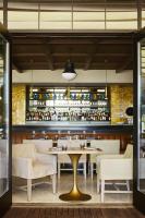 a restaurant with a table and chairs and a bar at The Aster in Los Angeles