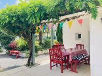 a table and chairs under a pergola with flags at La Blatière French Cottages in La Chapelle-Saint-Étienne