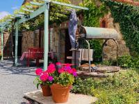 a patio with two pots of flowers and an umbrella at La Blatière French Cottages in La Chapelle-Saint-Étienne